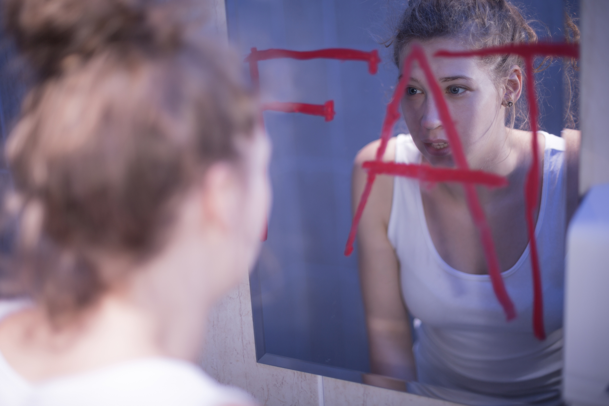 鏡を見ると自分が太っていると思う若い女性。