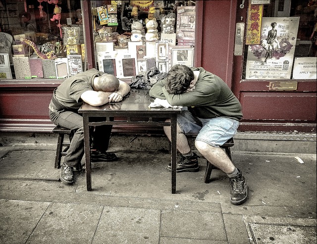 店の外のテーブルで眠る2人の男。 古い店だ。