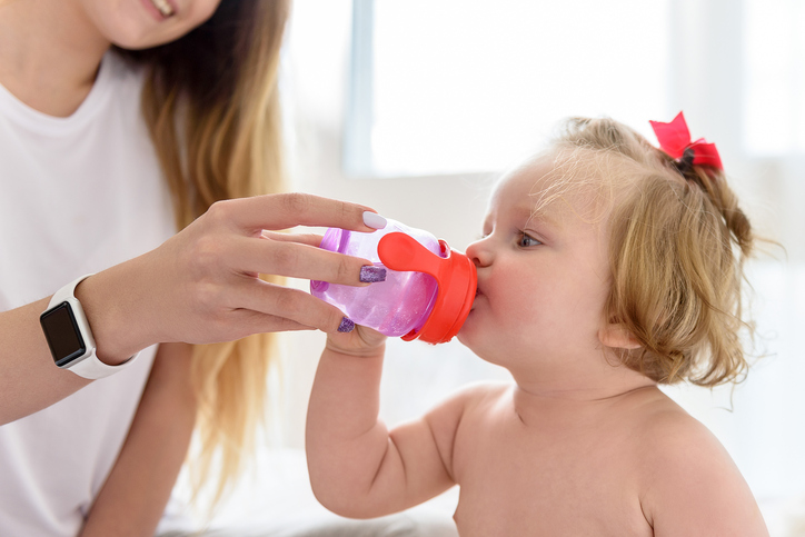 母親が少女にきれいな水を飲ませる