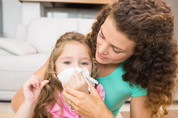 子供が鼻水を垂らし、母親が分泌物たっぷりの鼻をかむ。