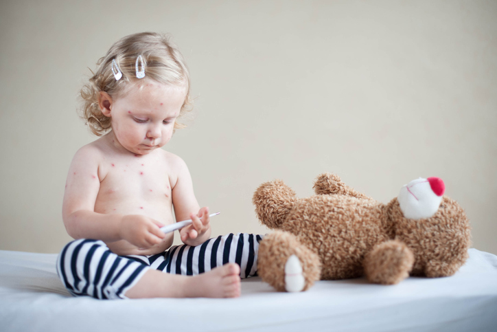 はしかの子供がテディベアと遊ぶ