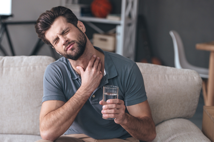 喉の痛みを訴える男性-水を飲んで悪化