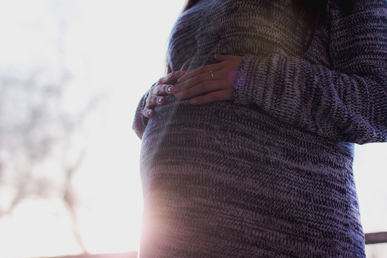 女性、妊娠、お腹に手、太陽